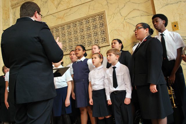 Zane Morris leads the Portland Tabernacle singing company in the lobby of the Arlene Schnitzer Concert Hall prior to "Something Grand." Lt. Jennie Onitsuka-Adams, assistant corps officer at Portland Tabernacle, lends her voice to the choral group.
