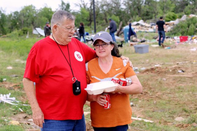Salvationist comforts a tornado survivor.