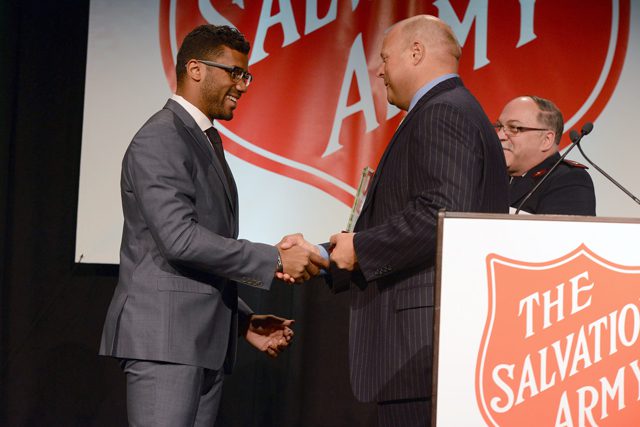 Russell Wilson accepts an award from Arthur K. Langlie at the Red Kettle Luncheon in Seattle.