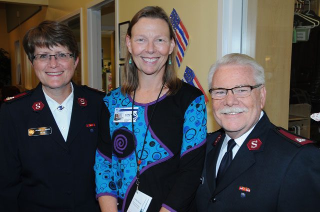(l-r) Major Jeanne Baker, Alaska divisional director of women’s ministries, Cathy Brenner, Serendipity director, and Major George Baker, divisional commander, greet the Red Shield Society event attendees.