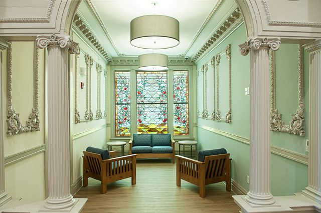third floor casual sitting area featuring intricate stained glass landscape, c. 1907.
