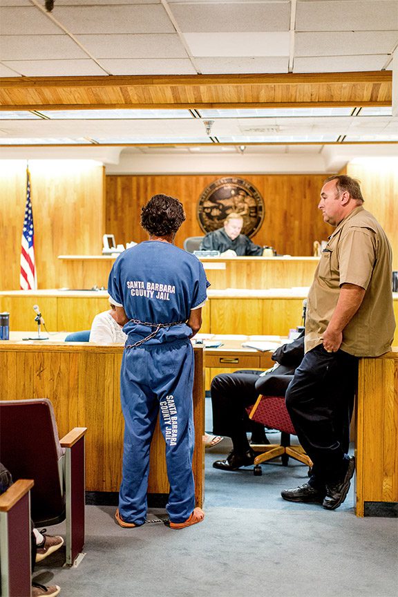 Person in prison jumpsuit in courtroom