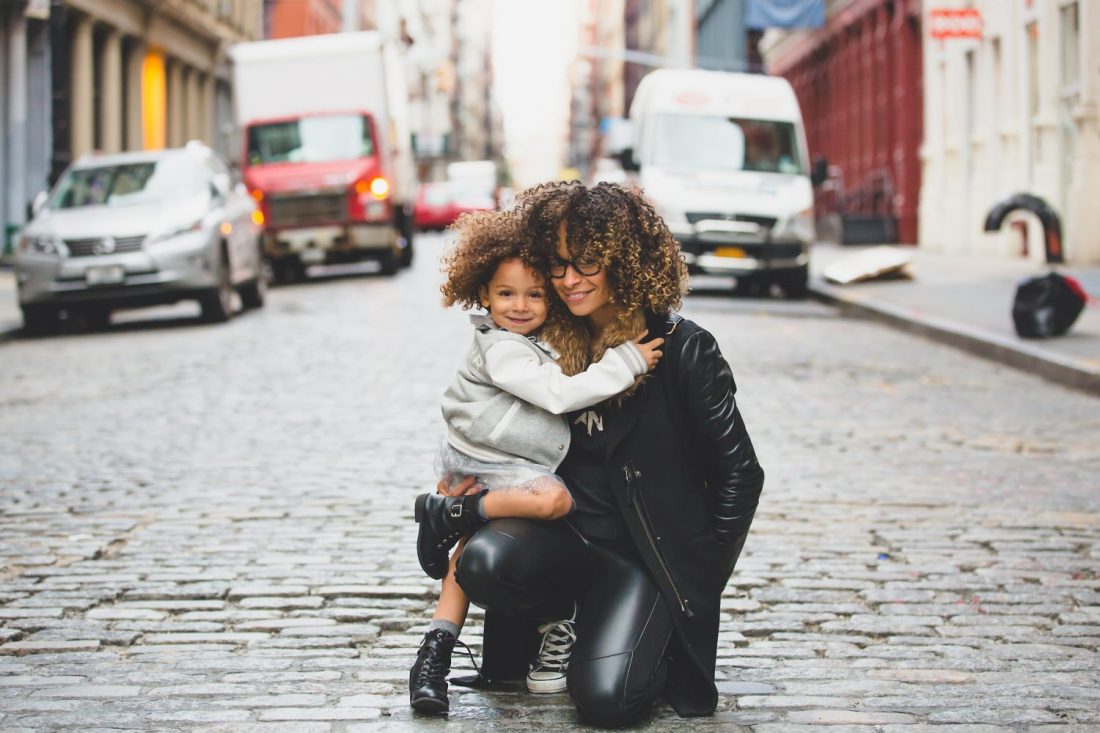 Mother and Daughter hugging in street