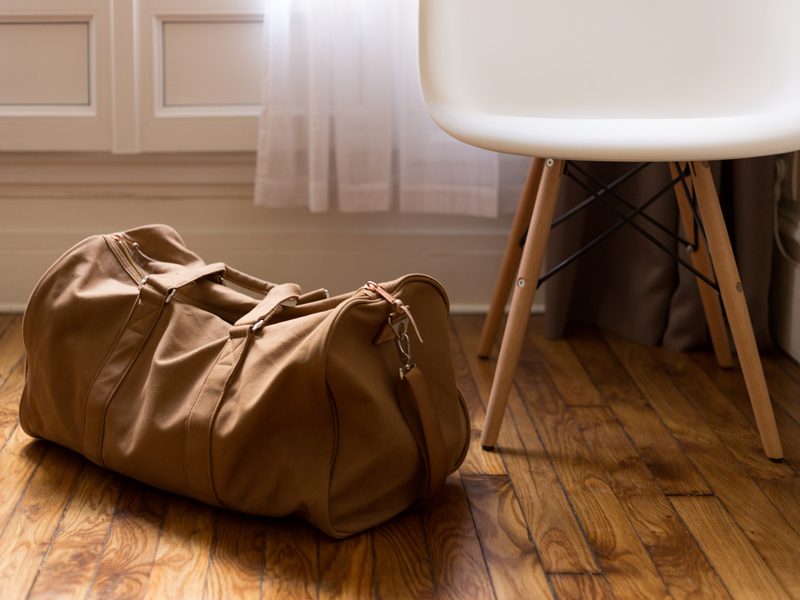 Duffel bag on ground next to chair