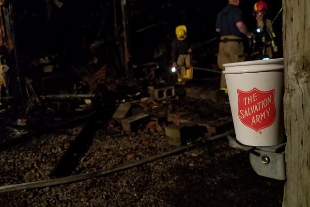 Salvation Army Bucket in Front of Burned Down Area