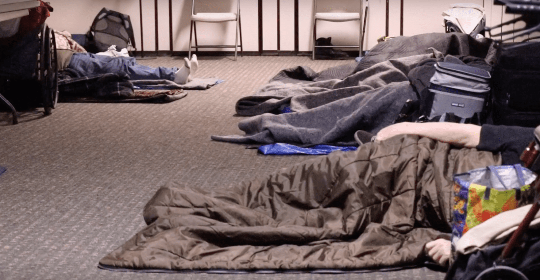 People sleeping in sleeping bags indoors