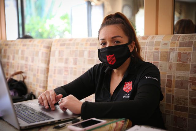 Woman with mask on working on computer