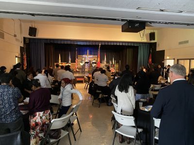 Group of people sitting inside with stage in background