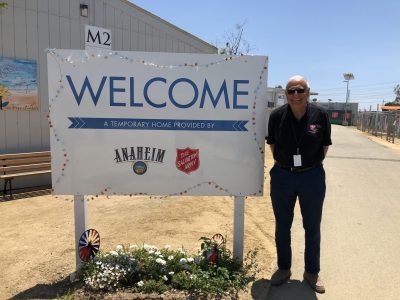 Man standing outside next to sign