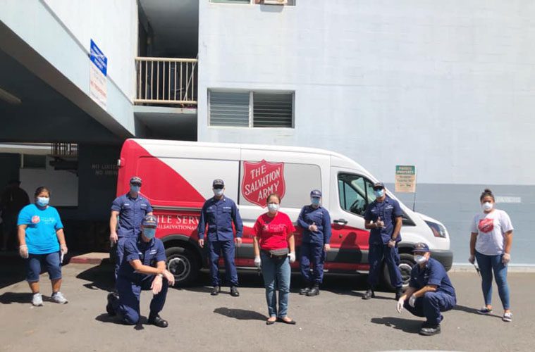 Salvation Army workers standing in front of van