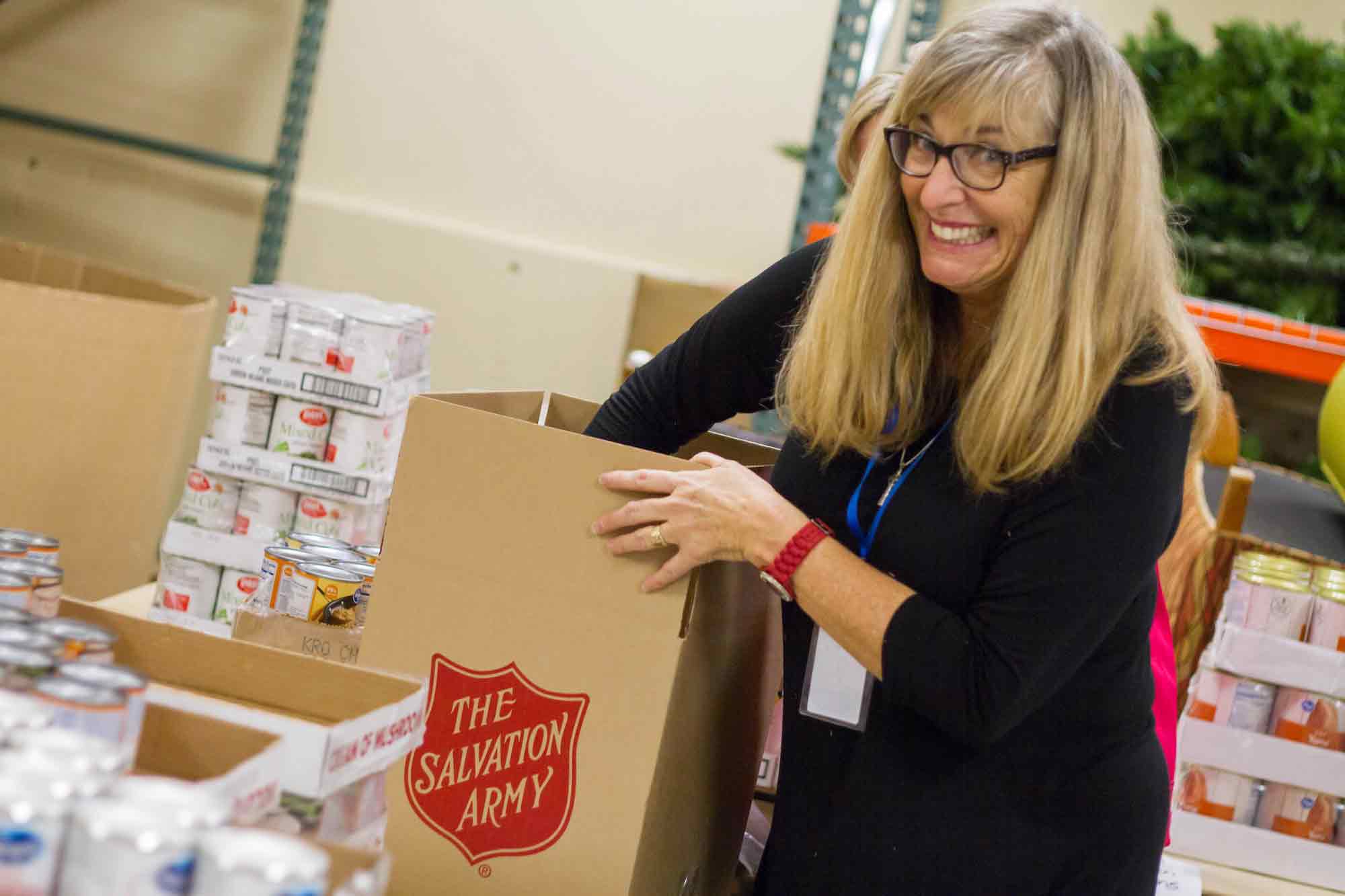 woman volunteers packing food boxes at the salvation army